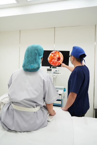 แพทย์กำลังอธิบายคนไข้ถึงสิ่งที่พบจากการผ่าตัดเหนียงแบบส่องกล้องที่ HERS clinic